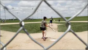  ?? CHARLIE NEIBERGALL ?? Visitors play on the field at the Field of Dreams movie site, Friday, June 5, 2020, in Dyersville, Iowa. Major League Baseball is building another field a few hundred yards down a corn-lined path from the famous movie site in eastern Iowa but unlike the original, it’s unclear whether teams will show up for a game this time as the league and its players struggle to agree on plans for a coronaviru­s-shortened season.