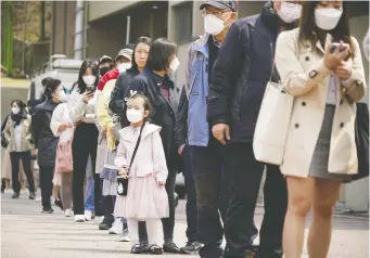  ?? KIM HONG-JI/REUTERS ?? People wearing masks in an effort to prevent the spread of the coronaviru­s line up to vote at a polling station in Seoul on Wednesday. The ruling party was re-elected.