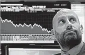  ?? RICHARD DREW/AP ?? Meric Greenbaum checks numbers from his post on the floor of the New York Stock Exchange on Wednesday.