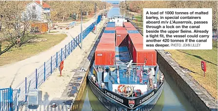  ?? PHOTO: JOHN LILLEY ?? A load of 1000 tonnes of malted barley, in special containers aboard m/v L’Auxerrois, passes through a lock on the canal beside the upper Seine. Already a tight fit, the vessel could carry another 420 tonnes if the canal was deeper.