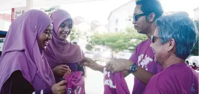  ??  ?? AHMAD Fakhri bersama Renee (kanan) mengagih bubur lambuk percuma daripada Kembara Srikandi Prihatin kepada pengunjung di stesen Shell Seksyen 7, Shah Alam.