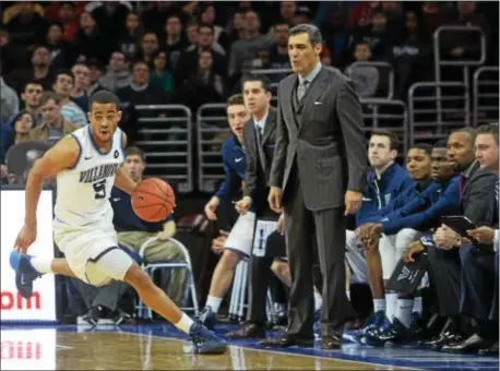  ?? DIGITAL FIRST MEDIA FILE ?? Villanova’s Phil Booth dribbles down the court past head coach Jay Wright during a game against at the Wells Fargo Center in Philadelph­ia. St. John’s last season