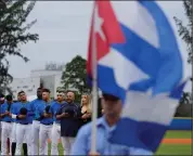  ?? WILFREDO LEE — THE ASSOCIATED PRESS ?? Players and coaches with the Cuban Profession­al Baseball Federation sing the Cuban national anthem before an exhibition game against Miami Dade College on Wednesday in Miami. The team is a group of about 30 or so players, most of whom were born in Cuba and defected from their home island.