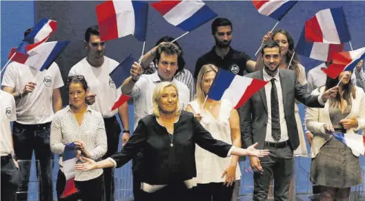  ?? JEAN PAUL PELISSIER / REUTERS ?? Marine Le Pen (centro), rodeada de jóvenes, en un acto electoral para las municipale­s francesas celebrado en el 2019.