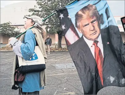  ??  ?? A supporter carries a Donald Trump flag during a rally held by far-right Proud Boys in Portland, Oregon last weekend