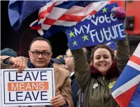  ?? AFP ?? a pro-brexit protester (l) and a supporter of a second eu referendum (R) hold up their placards next to each other outside the houses of parliament in london on tuesday. —