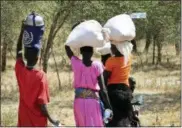  ?? SAM MEDNICK — THE ASSOCIATED PRESS ?? In this photo taken Friday women and girls walk back after getting food in Bentiu, a 38 kilometers (24 miles) journey using a path through the bush for fear of being attacked on the main road, near Nhialdu in South Sudan. Rape has been used widely as a weapon in South Sudan and even after a peace deal was signed in September, humanitari­ans have warned of higher rates of sexual assault as growing numbers of desperate people try to reach aid.