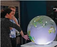  ?? — afp ?? A participan­t interacts with a globe at the Sharm El Sheikh Internatio­nal Convention Centre during the COP27 climate conference on Monday.