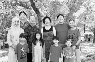  ??  ?? Adrian (back) and his wife Siti Nurzaini celebratin­g Chinese New Year with their family. — Bernama photo