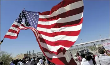  ??  ?? In this Thursday photo, protesters and media gather outside a closed gate at the port of entry facility, where tent shelters are being used to house separated family members in Fabens, Texas. AP PHOTO/MATT YORK