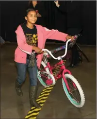  ?? The Sentinel-Record/Richard Rasmussen ?? WINNER: Jalissa Davis, 10, of Hot Springs, is all smiles after winning a bicycle at the 32nd annual Christmas for Kids event at the Hot Springs Convention Center on Thursday.