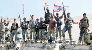  ??  ?? Lebanese soldiers flash the victory sign in Ras Baalbek, Lebanon. (Reuters)