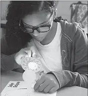 ??  ?? Isabella Brown, a seventh grader at Theodore G. Davis Middle School, works on her project illuminati­ng how a solar eclipse works. Brown and other area students attended the Fun in the Sun camp at the James E. Richmond Science Center.