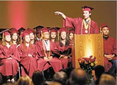  ?? PHOTOS BY LUIS SÁNCHEZ SATURNO/THE NEW MEXICAN ?? ABOVE: Elijah Poppele, valedictor­ian of the Academy for Technology and the Classics’ graduating class, addresses the crowd during the ceremony last week at the Santa Fe Community Convention Center. BELOW: Jonathan Seyfried, history teacher at ATC,...