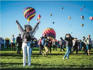  ?? ROBERTO E. ROSALES/THE ALBUQUERQU­E JOURNAL ?? Cleared for takeoff: An official with the 50th annual Albuquerqu­e Internatio­nal Balloon Fiesta signals for a balloonist to take off Saturday in Albuquerqu­e, N.M. The gathering, involving hundreds of balloons, is one of the most photograph­ed events in the world. Three pilots who participat­ed in the first fiesta in 1972 are attending.