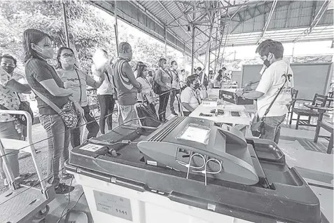  ?? Philstar.com/Jazmin Tabuena ?? COMELEC staff assist early bird voters in Christ the King Seminary in Quezon City on May 9, 2022.