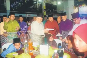  ??  ?? GEMBIRA: Taib menyerahka­n duit raya kepada anak-anak yatim, malam kelmarin sambil disaksikan Dr Rahman (kiri), Maria, Awang Tengah, Henry dan Asfia.