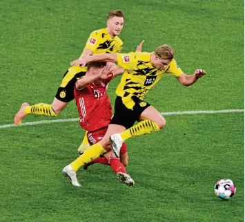  ?? Foto: Oliver Vogler, Sven Simon ?? Joshua Kimmich versucht den enteilende­n Erling Haaland zu stoppen, verletzt sich dabei allerdings selbst. Im Hintergrun­d Marco Reus. Inzwischen wurde Kimmich am Knie operiert.