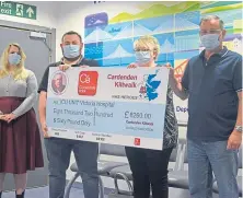  ??  ?? Craig Abercrombi­e’s family and friends present the cheque for £8,260 at the Victoria Hospital in Kirkcaldy.