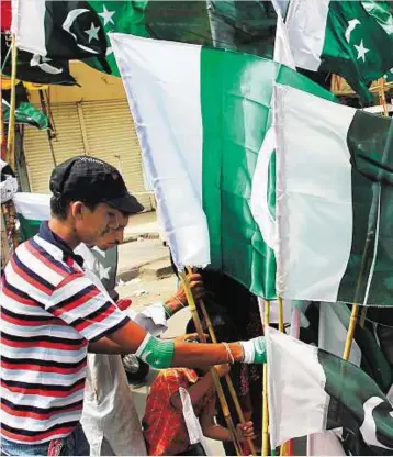  ?? EPA ?? A Pakistani man sells national flags at a market as the nation prepares to celebrate the Independen­ce Day, in Karachi, yesterday. Pakistan will celebrate its 65th independen­ce anniversar­y from British on August 14.