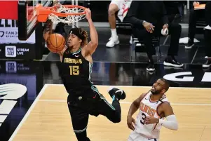  ?? The Associated Press ?? Q Memphis Grizzlies forward Brandon Clarke (15) dunks ahead of Phoenix Suns guard Chris Paul (3) in the first half of Monday’s NBA game in Memphis, Tenn.