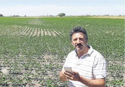  ??  ?? Con su chiche. Calvigioni, en un lote en Pergamino, probando la aplicación desde su smartphone.