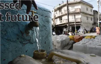  ?? ?? A container is filled with water at a public fountain in Niarry Tally, a neighborho­od of Dakar.