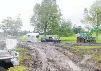  ??  ?? Left, a tractor tows a ute and horse float through mud at the showground­s entrance last year.