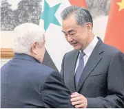  ?? AP ?? Syrian Foreign Minister Walid Muallem, left, greets Chinese Foreign Minister Wang Yi during a meeting at Diaoyutai state guesthouse in Beijing yesterday.