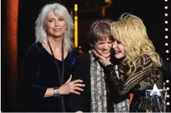  ?? Associated Press ?? ■ Emmylou Harris, from left, and Linda Ronstadt present Dolly Parton with the MusiCares Person of the Year award on Friday at the Los Angeles Convention Center.