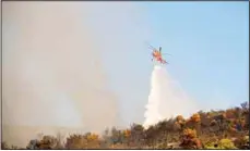  ??  ?? A helicopter drops water over a fire in Peania, eastern Athens on Aug 12. A big fire broke out in the Athens suburb of Peania east of the city, and authoritie­s
ordered the evacuation of nearby houses. (AP)