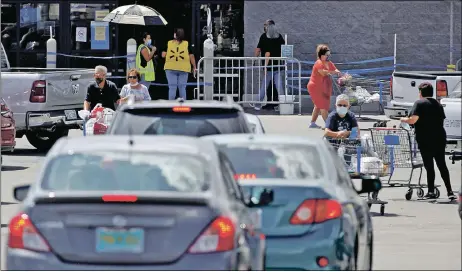  ?? LUIS SÁNCHEZ SATURNO/New Mexican file photo ?? Shoppers fill the parking lot outside Walmart in Española in the fall. Big-box stores are allowed to have up to 25 percent of their capacity or 75 shoppers under a 14-day lockdown in New Mexico that began Nov. 16. Small retail businesses say that creates an unfair advantage for big companies.