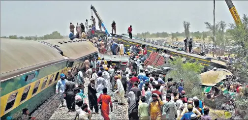 ?? AFP ?? Security personnel and onlookers stand at the site of a train accident in Daharki area of Pakistan’s northern Sindh province on Monday.