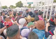  ??  ?? Los centroamer­icanos corren por la puerta del cruce fronterizo en Ciudad Hidalgo.