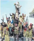  ?? FOTO: DPA ?? Soldaten der von der Türkei unterstütz­ten Freien Syrischen Armee (FSA) feiern vor einer Statue von Kawa, einer Gestalt aus der kurdischen Mythologie, bevor sie diese zerstören.