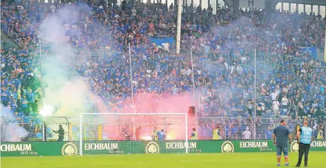  ?? FOTO: SAMLA ?? Die Szenen ab der 82. Minute im Carl-Benz-Stadion: Vermummte Chaoten im Mannheimer Fanblock zünden bengalisch­e Feuer an. Die Situation eskaliert so sehr, dass die Partie zwischen dem KFC uerdingen und Waldhof Mannheim abgebroche­n werden muss.