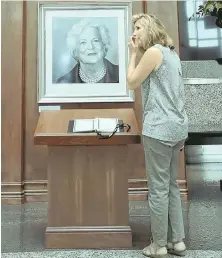  ?? AP PHOTOS ?? PAYING RESPECTS: Jeanne Wagner, above, pauses after signing a condolence book at the George Bush Presidenti­al Library and Museum in College Station, Texas. Above right, the flag flies at half-staff at the Bushes’ summer home in Kennebunkp­ort, Maine.