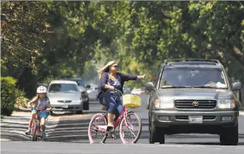  ?? Liz Hafalia / The Chronicle ?? Jessica Clark rides home with her 7-year-old daughter, Penelope, last week. The family has experience­d the pressure and insecurity of high housing costs.