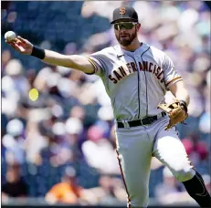  ?? PHOTOS BY DAVID ZALUBOWSKI — THE ASSOCIATED PRESS ?? Giants third baseman Evan Longoria throws to first base to put out the Rockies' Randal Grichuk to end the first inning on Wednesday in Denver.