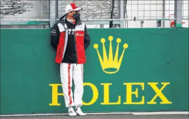  ??  ?? Kimi Raikkonen se concentra apoyado sobre las proteccion­es antes de empezar la carrera en Hungría.