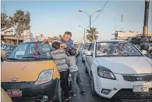  ??  ?? Said Dadoush, 14, whose father was killed, cleans the windshield of a passing car at a busy intersecti­on in eastern Mosul.