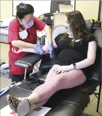  ?? Brodie Johnson • Times-Herald ?? Red Cross volunteer MaLi Imhoff, left, draws blood from Forrest City Medical Center Marketing Director Caitlyn Sweet. The Red Cross collected several pints of blood during a drive held Friday at the hospital.