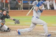  ??  ?? Dodgers first baseman Cody Bellinger hits a two- run homer in the third inning against the Marlins on Saturday.
| AP