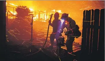  ?? Marcus Yam Los Angeles Times ?? FIREFIGHTE­RS, shown facing a 2019 San Bernardino fire, will be vulnerable to COVID-19 this year.