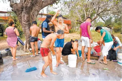  ?? VICTORIA RAZO/AFP ?? Integrante­s de la movilizaci­ón toman un baño en el municipio oaxaqueño de Matías Romero.