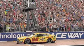  ?? JEFF ROBERSON/AP ?? Joey Logano takes the checkered flag for a second time in 2002, winning the NASCAR Cup Series race at World Wide Technology Raceway.