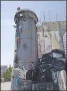  ?? AP PHOTO ?? A mural resembling the work of elusive artist Banksy depicts U.S. President Donald Trump kissing an Israeli army watchtower in Bethlehem.