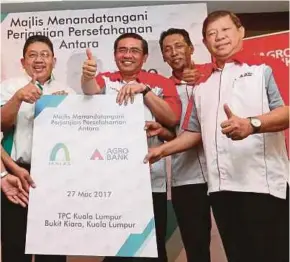  ?? PIC BY SALHANI IBRAHIM ?? Takaful Ikhlas Bhd president and CEO Datuk Ab Latiff Abu Bakar (left) and Agrobank president and chief executive officer Datuk Wan Mohd Fadzmi Wan Othman (second from left) at the signing ceremony in Kuala Lumpur yesterday.