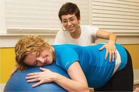  ??  ?? Kayla Bradbury, of Arkansas Family Doulas, provides support to the Ouachita River Valley area, including Hot Springs. Here, she helps a pregnant woman relax by using a birthing ball.