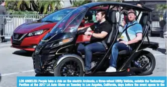  ??  ?? LOS ANGELES: People take a ride on the electric Arcimoto, a three-wheel Utility Vehicle, outside the Technology Pavilion at the 2017 LA Auto Show on Tuesday in Los Angeles, California, days before the event opens to the public running from tomorrow. —AFP